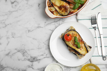 Delicious eggplant lasagna served on white marble table, flat lay. Space for text