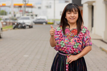 Fototapeta premium Young woman with her typical costume smiling with thumb up-Young happy hispanic woman in her city in Latin America-Latin woman with typical costume