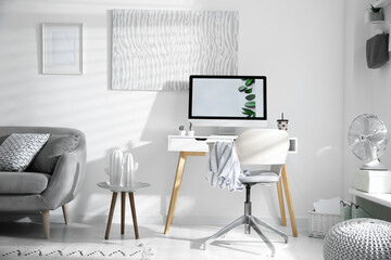 Comfortable office chair near desk with modern computer indoors