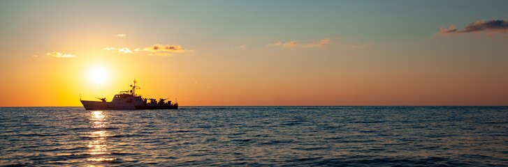 A ship at sunset on the sea horizon