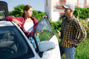 Hardworking farmers, having finished working, communicate standing by the car, discussing topical...