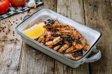 boiled shrimp on plate with lemon and black caviar
