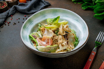 Salad with seafood on bowl on brown table