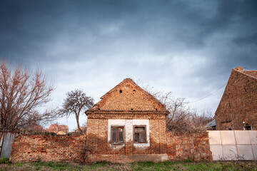 Facade of old house building from an abandoned farmhouse in alibunar, banat, Voivodina, in Serbia. The region of Balkans, in Europe, is hit by a severe rural exodus and emigration deserting the area