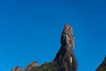 Famous mountain surrounded by hills located in the Teresópolis mountain range, in Rio de Janeiro, Brazil known as Dedo de Deus "Dedo de Deus". Sunny day