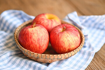 apple fruit on basket on the wooden table, ripe red apples