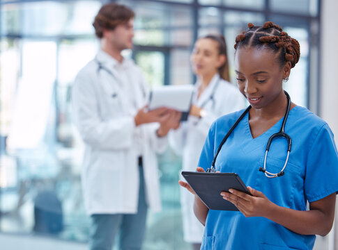 Female nurse or doctor browsing on a tablet for patient diagnosis or treatment on a medical or mobile healthcare app in a hospital. Professional gp or surgeon wearing scrubs while working in a clinic