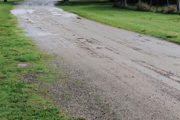 muddy dirt road through field