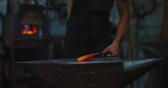 hammering metal billet on anvil in forge, closeup view, blacksmith is working, 4K, Prores