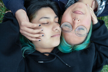 High angle photo of a lesbian couple lying together in a park