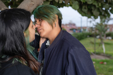 Lesbian couple about to kiss each other outdoors