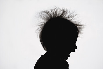 silhouette of child with crazy hair