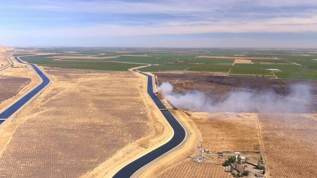 Bushfire Smoke Coming From The Extensive Lowland Of Central Valley Near Its Cultivated Farm Field In California, USA. Aerial 