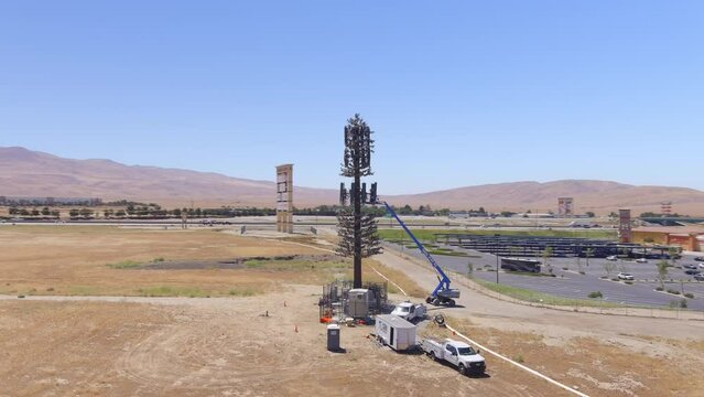 Mini Crane Mounted On A Telecommunication Tower During Repair Near Outlets At Tejon In California, United States. Aerial