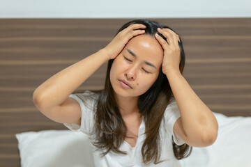 Fototapeta premium Asia woman has headache on bed.