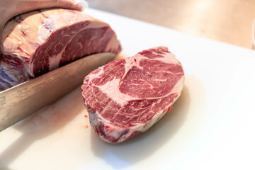 ステーキハウスの厨房でステーキをカットする