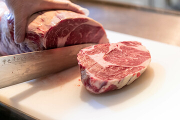 ステーキハウスの厨房でステーキをカットする