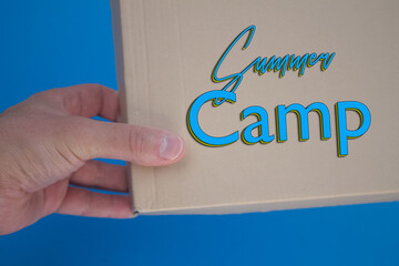 Summer Camp word with cardboard box. Brown folded cardbox.