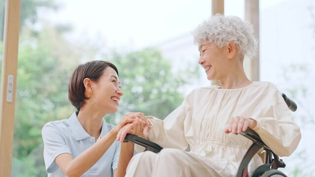 車椅子のシニア女性と介護士