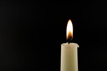 Candle flame and flowers against a black background