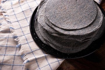 Fototapeta na wymiar Blue Corn Tortillas. Food made with nixtamalized corn, a staple food in several American countries, an essential element in many Latin American dishes.