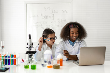 Group of teenage student learn with teacher and study doing a chemical experiment and holding test tube in hand in the experiment laboratory class on table at school.Education concept