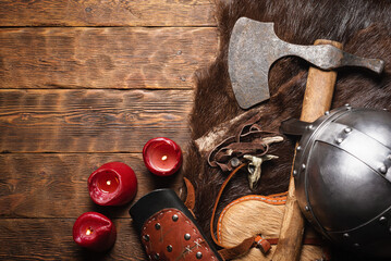 Ancient viking axe and beast fur skin on the old wooden table flat lay table background with copy...