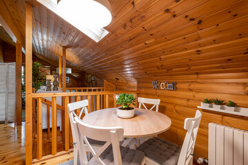 Round dining table with chairs on the second floor of completely wooden house.