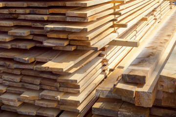 Wooden boards are stacked in a sawmill or carpentry shop. Sawing drying and marketing of wood. Industrial background