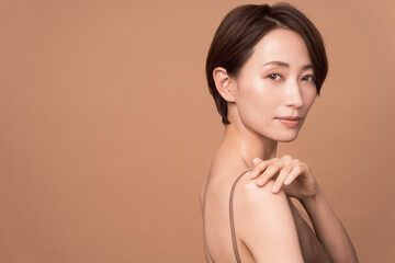 Obraz premium 美しいアジア人女性のビューティーイメージ。彼女は背中の見えるドレスを着ている。