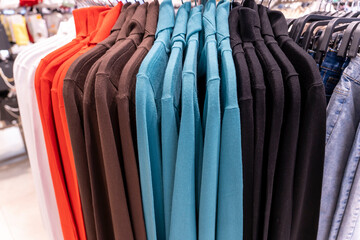 Close-up: casual clothes multi colored sweatshirts in clothing store