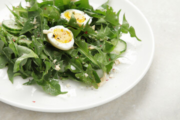 Fresh dandelion salad on light background.