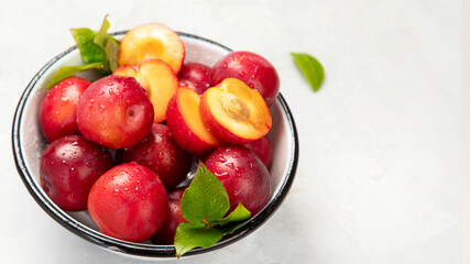 Naklejka na ściany i meble Plate of fresh ripe plums on table.