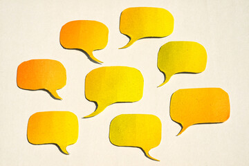 Yellow papercut speech bubbles on a white paper with copy space