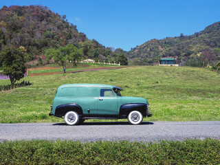 Side view of a classic  car from the fifties. the car is in excellent condition given the glossy paint and chrome.