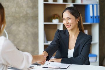 Business people shaking hand to agree to enter into a joint venture agreement to do business together in a new business.