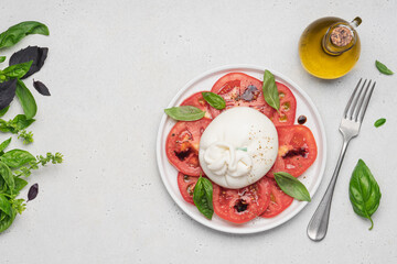 Tomato salad with buratta cheese or mozzarella and basil. Traditional italian salad, mediterranean cuisine