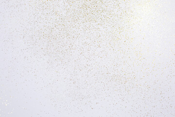Gold glitter scattered on white background