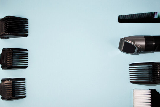 The haircut equipment: clipper with different attachments, comb and brush on a blue background with copy space