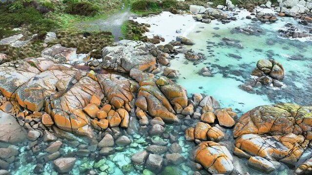 Panning left along the brightly coloured coastline of the Bay of Fires
