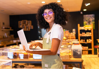 Cheerful black female vendor inventorying goods