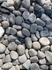 Shadows fall on a pile of round pebbles