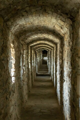 A long stone tunnel corridor with windows in an old castle. Selective focus.