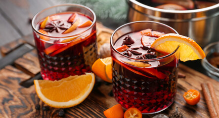 Glasses of delicious mulled wine on wooden board, closeup