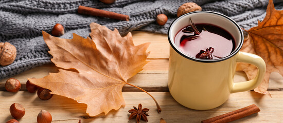 Mug of delicious mulled wine on wooden table