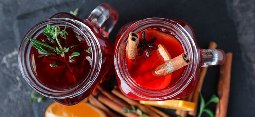 Tasty mulled wine in mason jars on grey background, top view