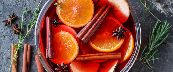 Tasty mulled wine with orange and apple slices in bowl on grey background, closeup - obrazy, fototapety, plakaty