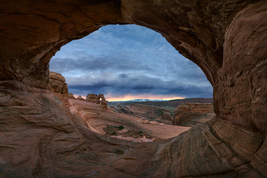 Stone arch and canyon against sunset sky