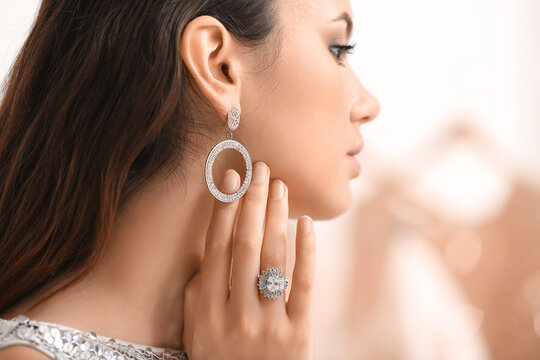 Beautiful young woman with stylish jewelry at home