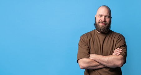 Bearded middle-aged white man in brown t-shirt over blue background. Mock up, template, copy space....